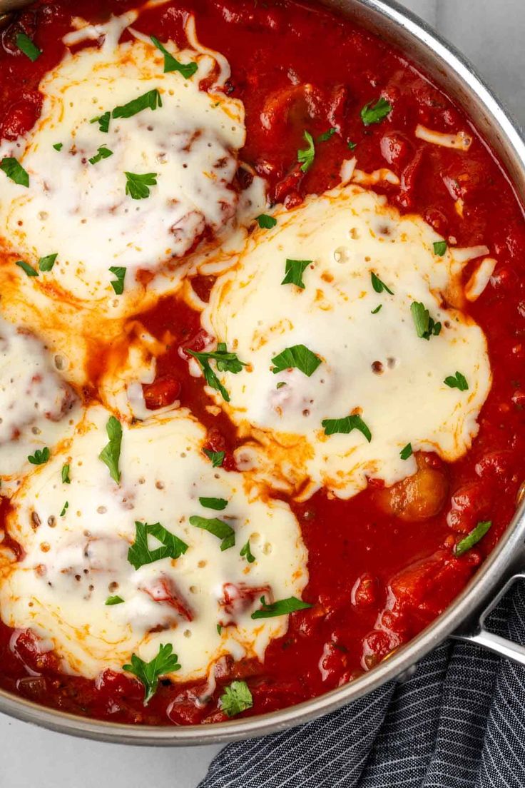 three ravioli with cheese and parsley in a skillet on a marble surface