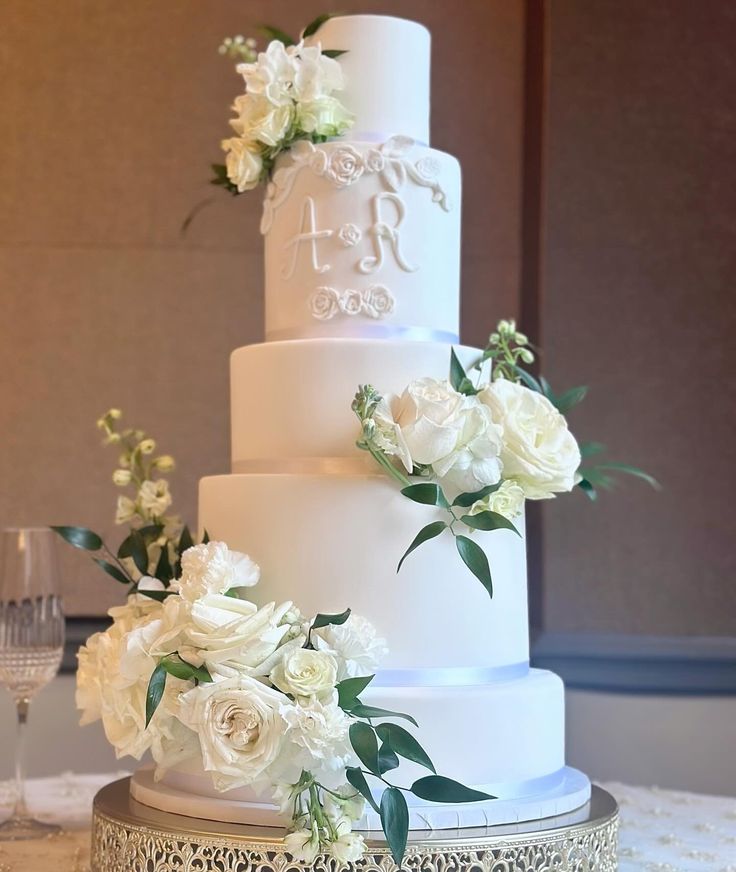 a wedding cake with white flowers and greenery