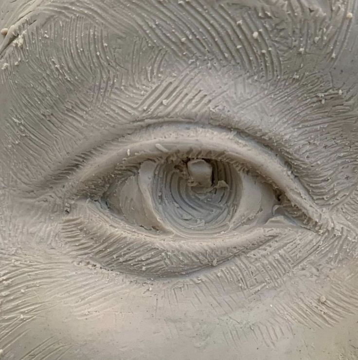 an eye is shown in the center of this image, and it appears to be made out of clay