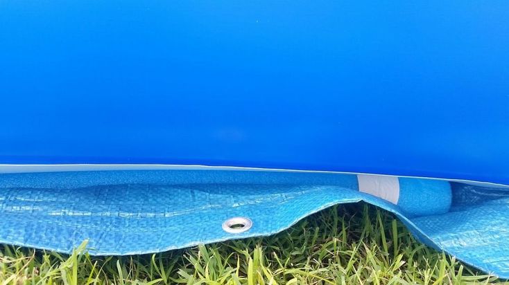 a blue surfboard laying in the grass with it's bottom section partially open