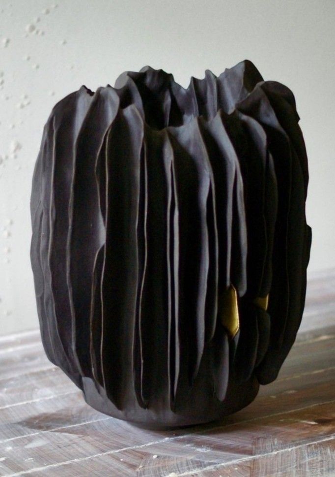 a black vase sitting on top of a wooden table