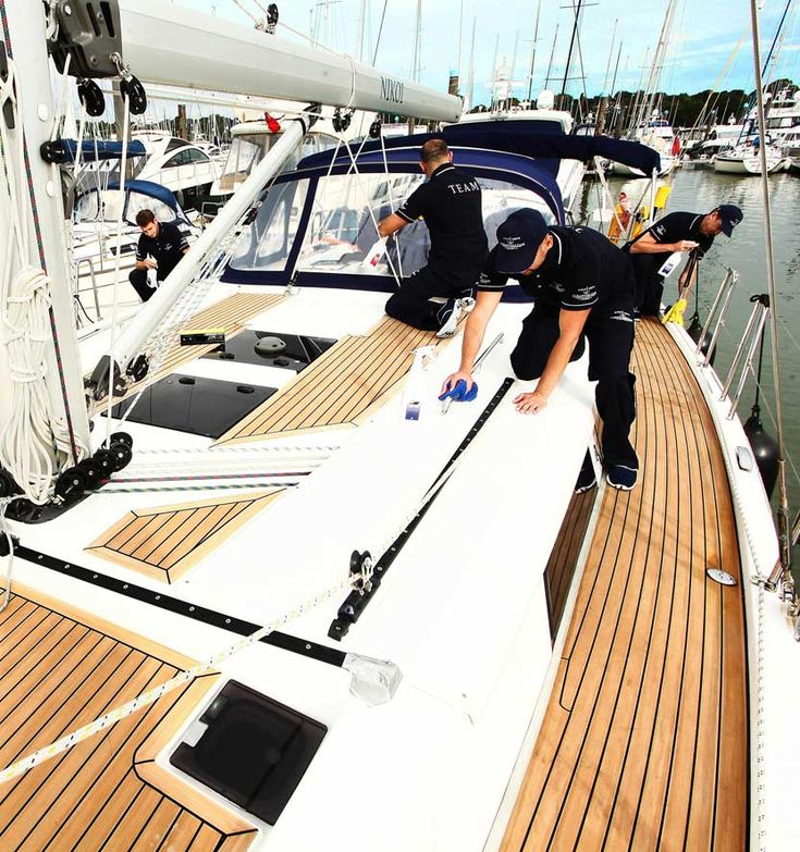 two men cleaning the deck of a sailboat