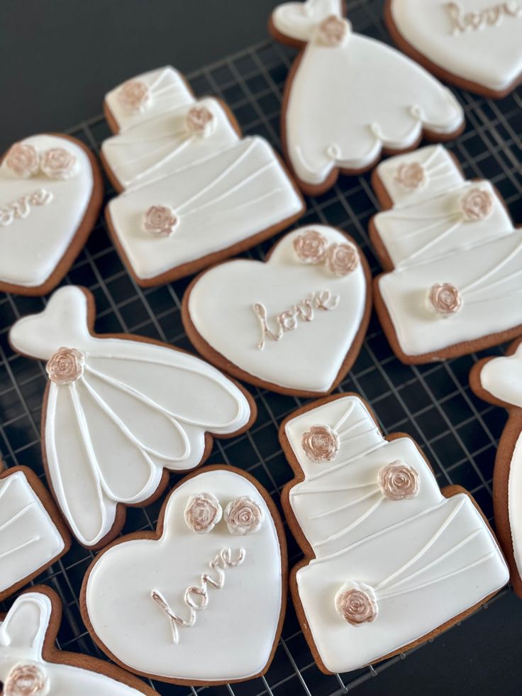 decorated cookies are arranged on a cooling rack for the bride and groom's arrival