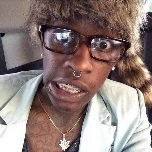 a woman with glasses and piercings on her nose is looking at the camera while wearing a jacket