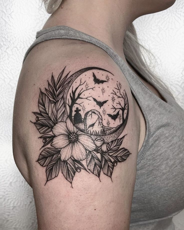 a woman's shoulder with a half moon and flowers on it