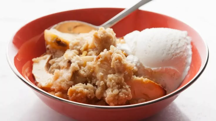 a red bowl filled with ice cream and some type of dessert on top of it