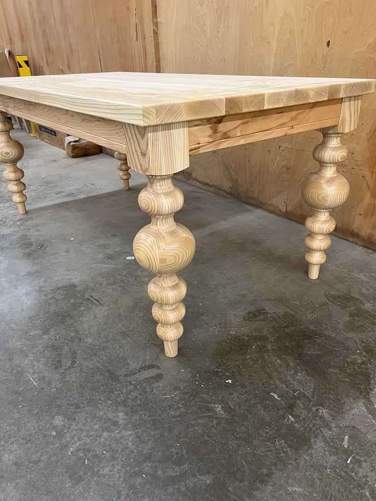 a wooden table sitting on top of a cement floor