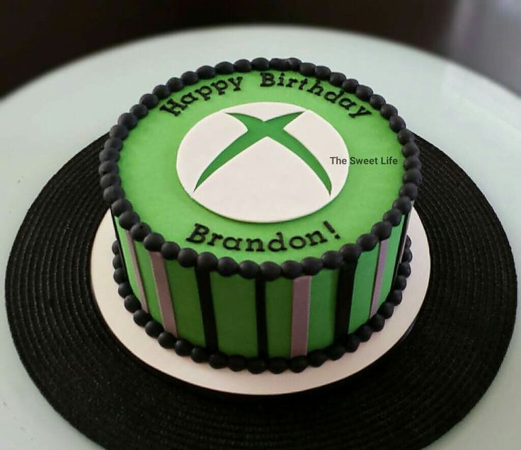 a green and black birthday cake sitting on top of a table