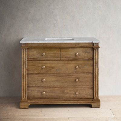 a wooden dresser with marble top and drawers