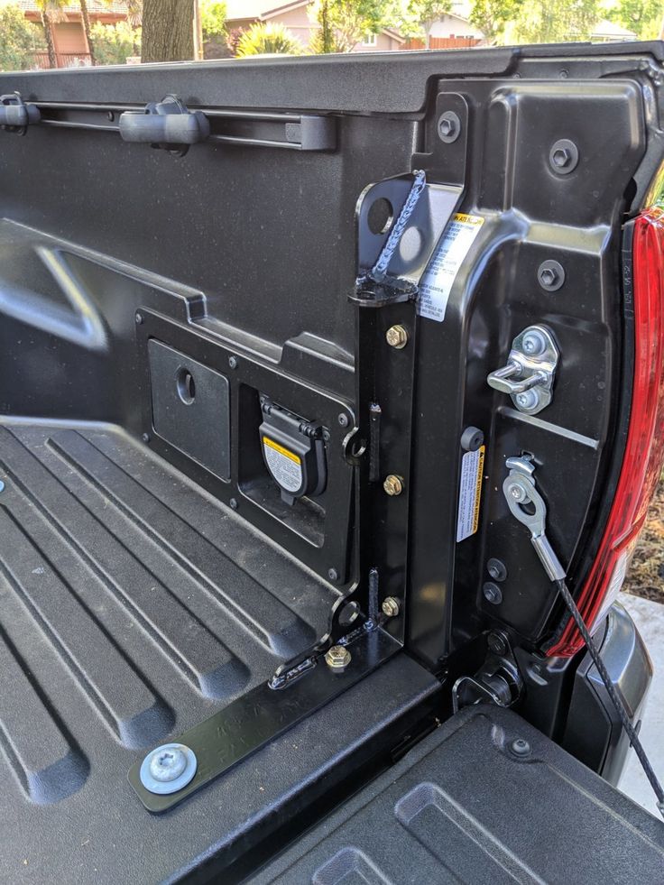 the back end of a pickup truck with its door open and tools in the trunk