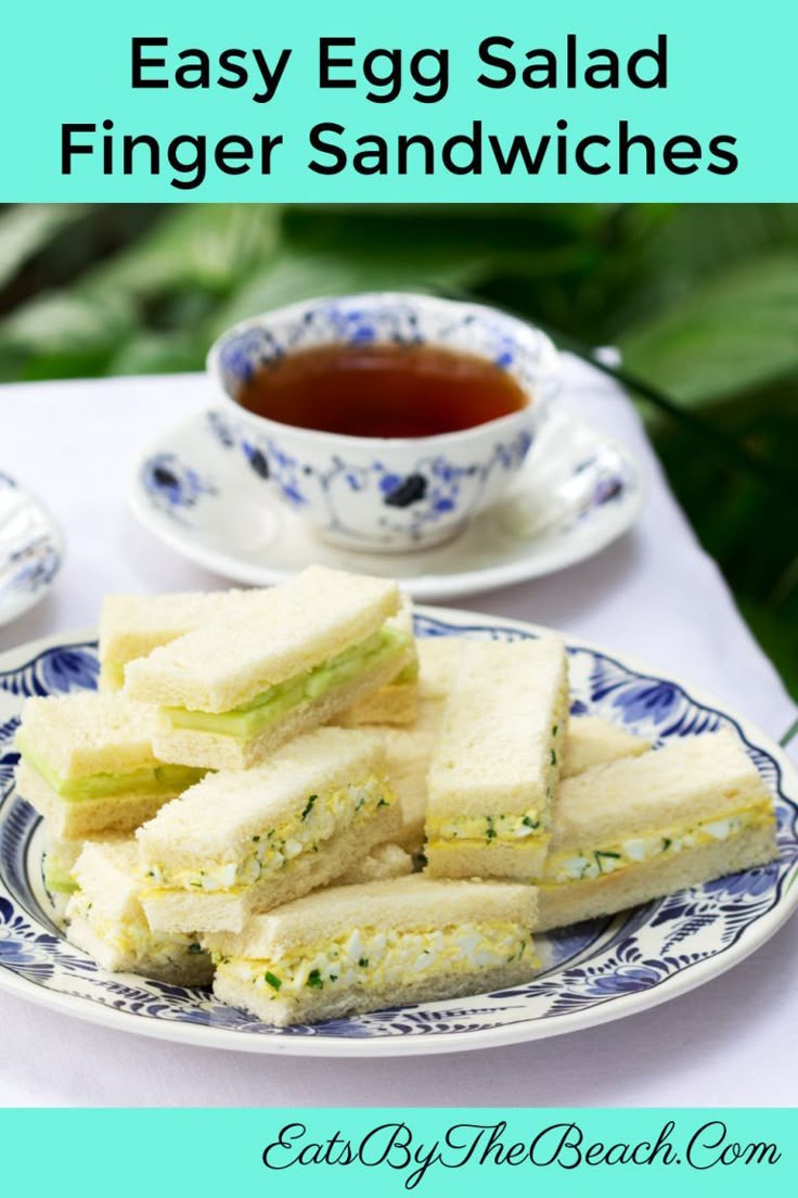 egg salad finger sandwiches on a blue and white plate next to a cup of tea