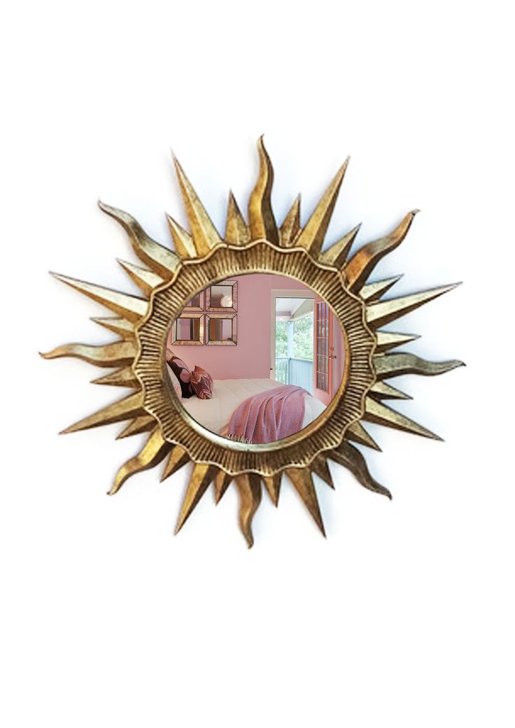 a mirror that is on the wall with a sun shaped object in it's center