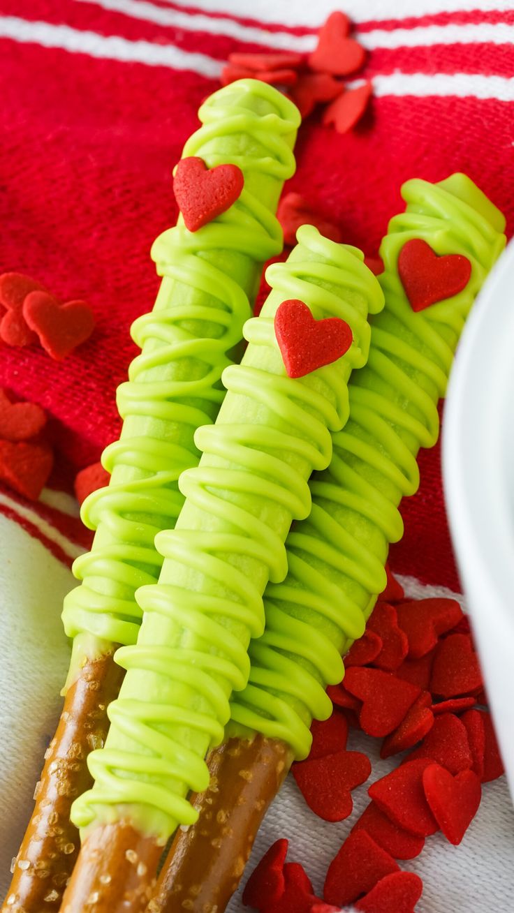 two pretzels with green frosting and hearts on them