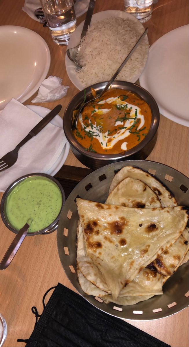 some food is sitting on a table with plates and silverware in front of it