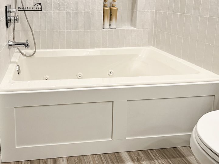 a white bathtub sitting next to a toilet in a bathroom under a shower head