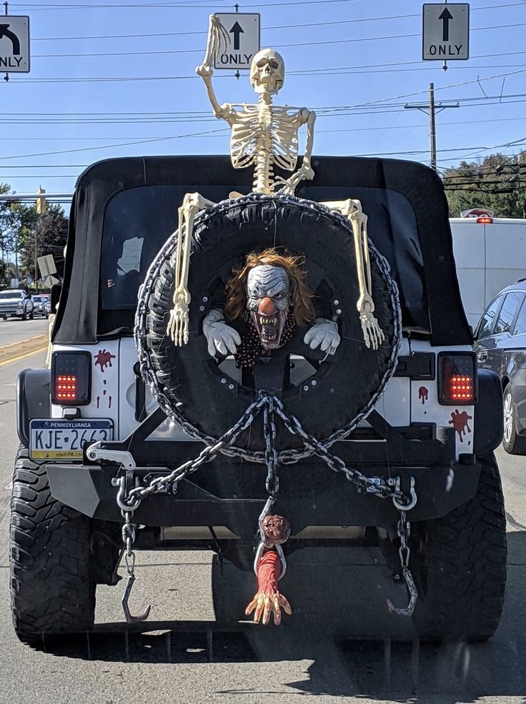 a car that has a skeleton on the back with chains attached to it's bumper