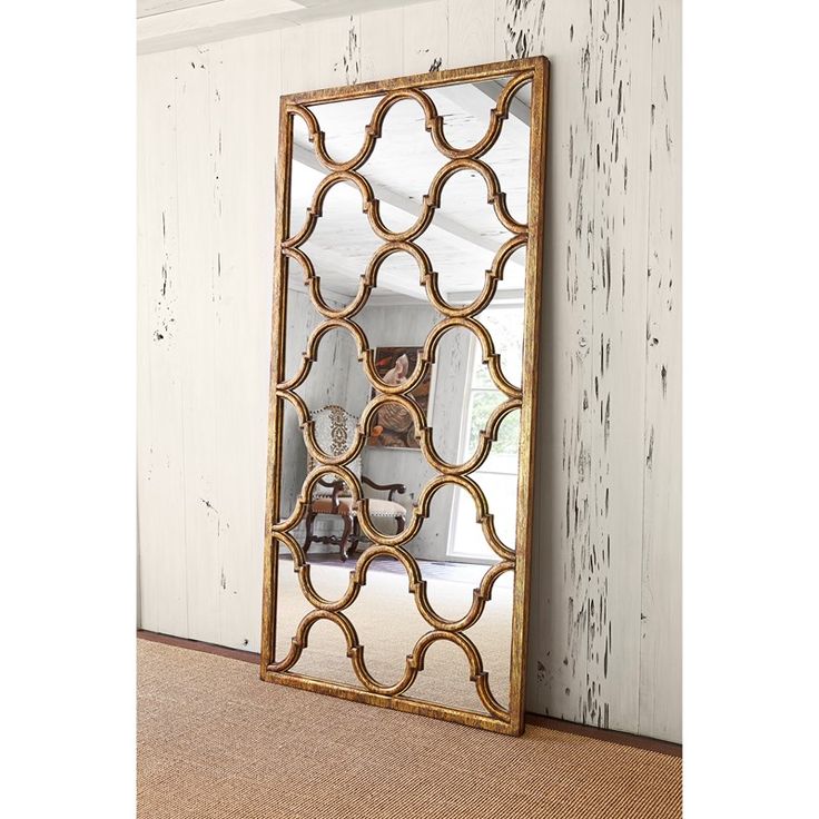 a large mirror sitting on top of a wooden floor next to a white painted wall