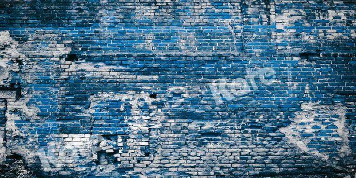 an old blue brick wall with graffiti on it