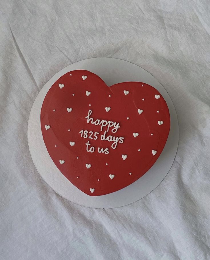 a cake shaped like a heart with the words happy valentine's day to us on it