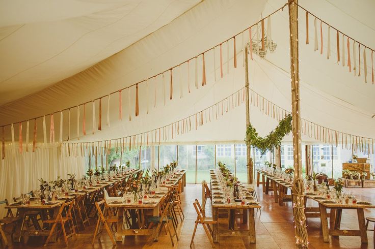 the inside of a large tent with tables and chairs set up for an outdoor event