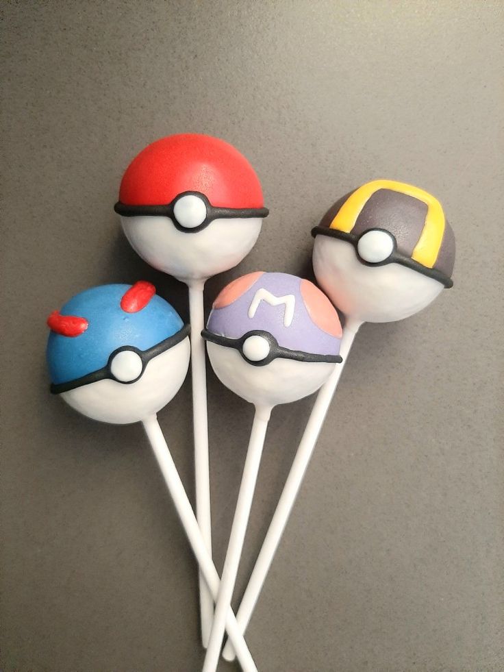 four lollipops with pokemon on them sitting on top of each other in front of a gray wall