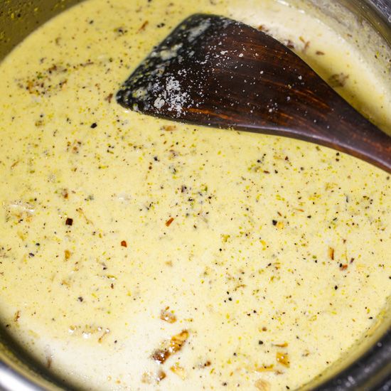 a wooden spoon in a pot filled with broth