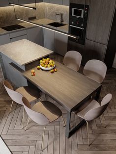 a modern kitchen with an island table and chairs in the center, along with a bowl of fruit on the countertop