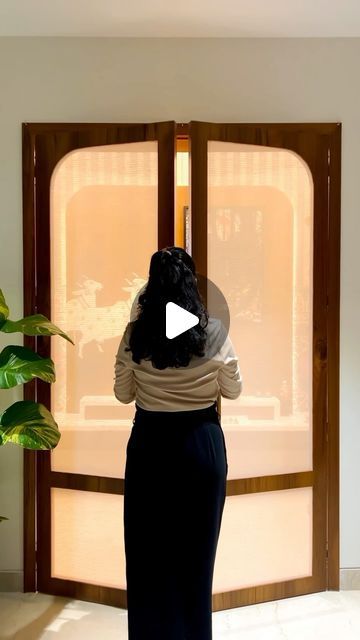 a woman standing in front of an open door with her back turned to the camera