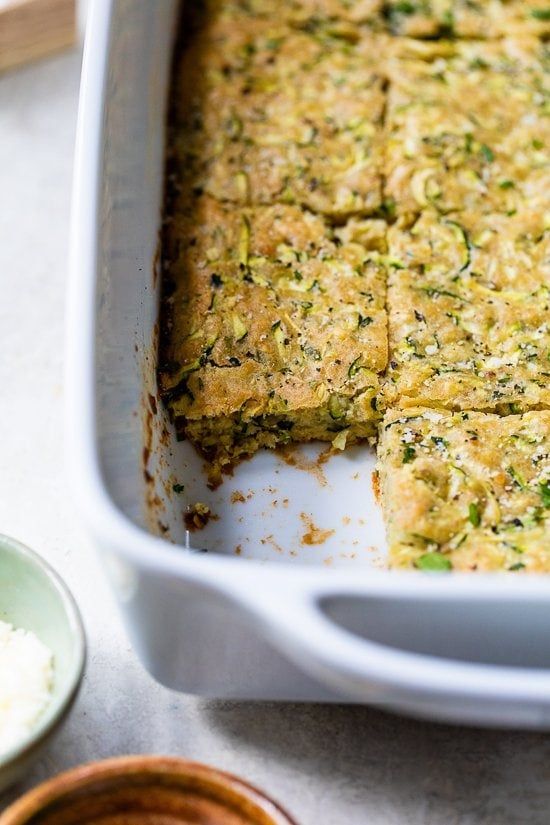 a casserole dish with broccoli and other food items on the side