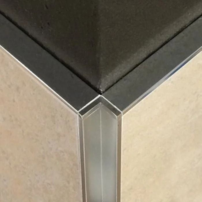 the corner of a bathroom with tile walls and flooring on top of it is shown