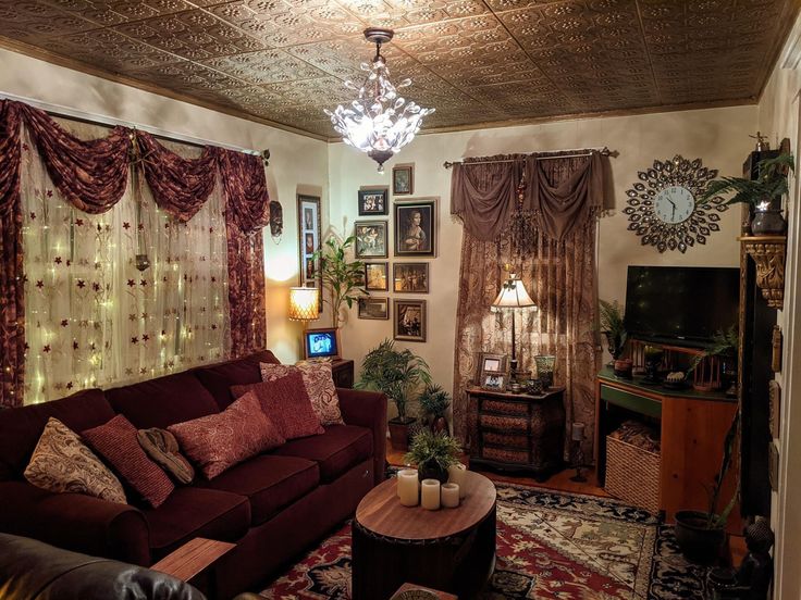 a living room filled with furniture and lots of windows covered in curtains on top of them