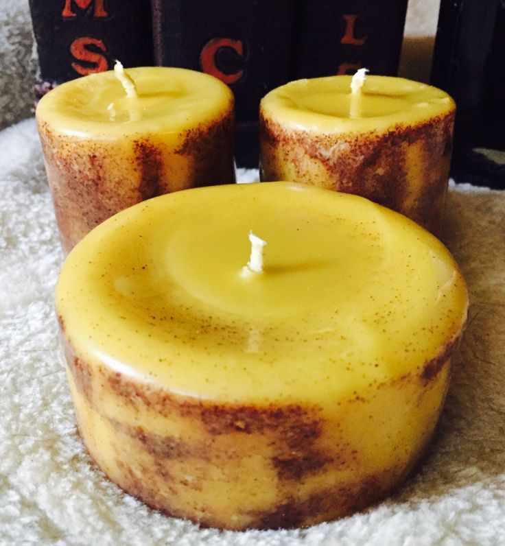 three yellow candles sitting on top of a white towel