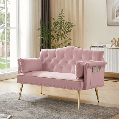 a living room with a pink couch and rug on the floor next to a window