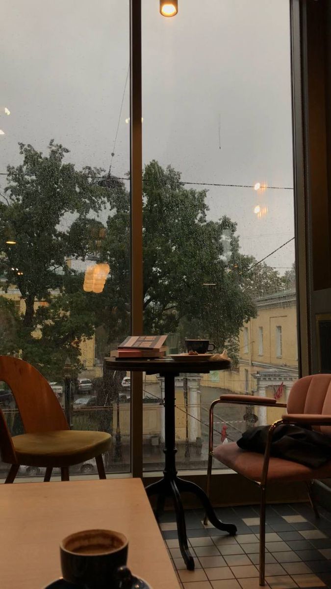 a coffee cup sitting on top of a table next to a window