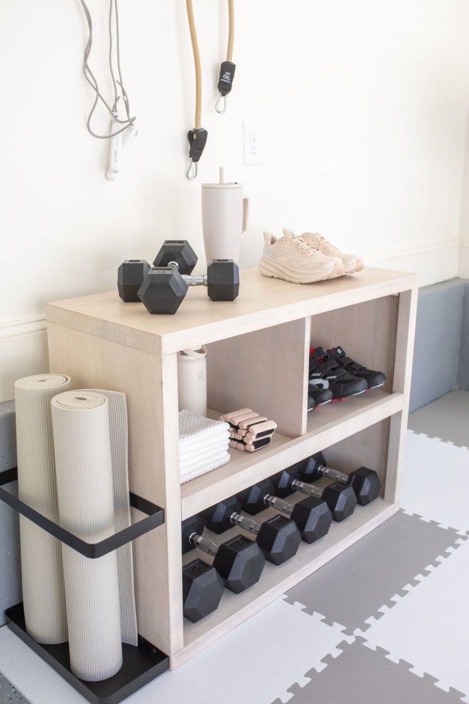 a white shelf with some black and white items on it next to a pair of dumbbells