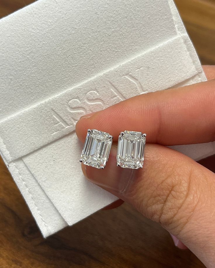 "Introducing a perfect matching pair of 4-carat emerald cut diamond stud earrings. The fine jewelry gift of a lifetime.  Unisex lab-grown CVD diamond stud earrings. Emerald cut, 4 carats each, 4-prong basket set with pushback closure, and IGI certified.  Hypoallergenic, and waterproof. Ships overnight from Miami Florida.   Setting Details:  - Metal: 14K Gold  - Setting: 4-Prong - Style: Basket Diamond Details:  - Carat: 4.01 - Cut: Emerald - Clarity: VVS2 - Color: H - Measurements: 10.64 x 7.56 Luxury Silver Earrings With Diamond Markers, Luxury Diamond Earrings With Square Cut, Luxury White Gold Emerald Cut Diamond Earrings, Luxury Baguette-cut Lab Grown Diamond Earrings, Luxury Emerald-cut Baguette Diamond Earrings, Luxury Classic Lab Grown Diamond Earrings, Estate Diamond Earrings, Luxury Baguette Cut Earrings For Engagement, Luxury Rectangular Earrings For Anniversary