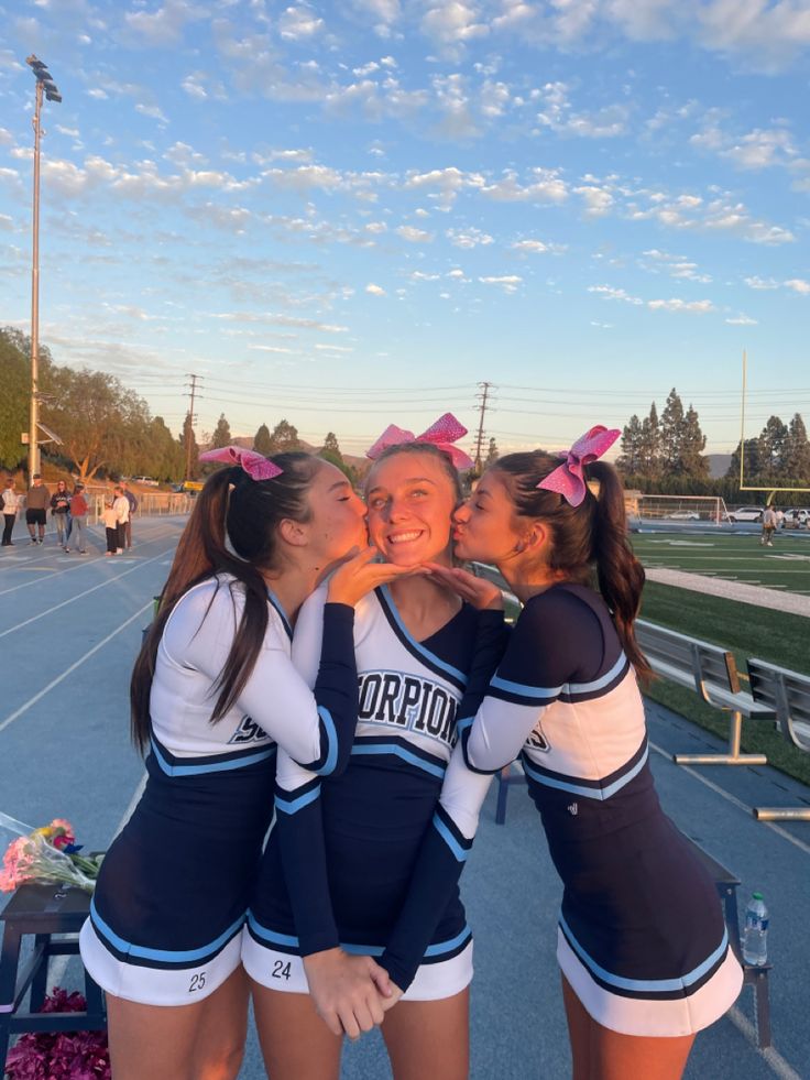 three cheerleaders are posing for the camera