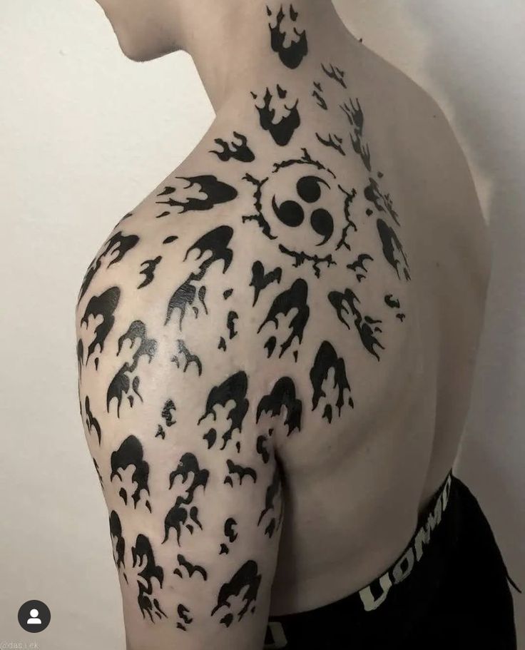 the back of a man's shoulder with black and white animal tattoos on it