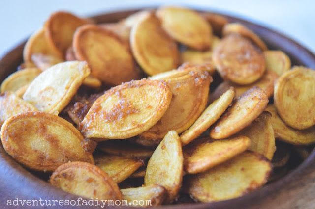 a wooden bowl filled with fried potatoes on top of a table