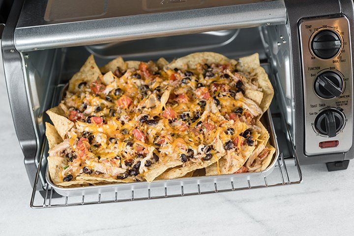 a toaster oven filled with nachos and tortilla chips in it