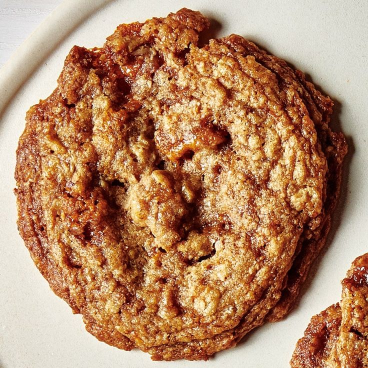 two cookies on a white plate sitting next to each other