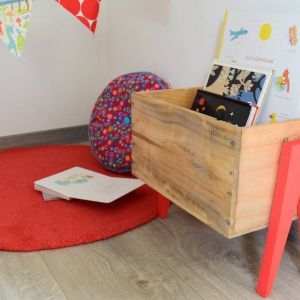 a child's playroom with books and toys in the storage box on the floor