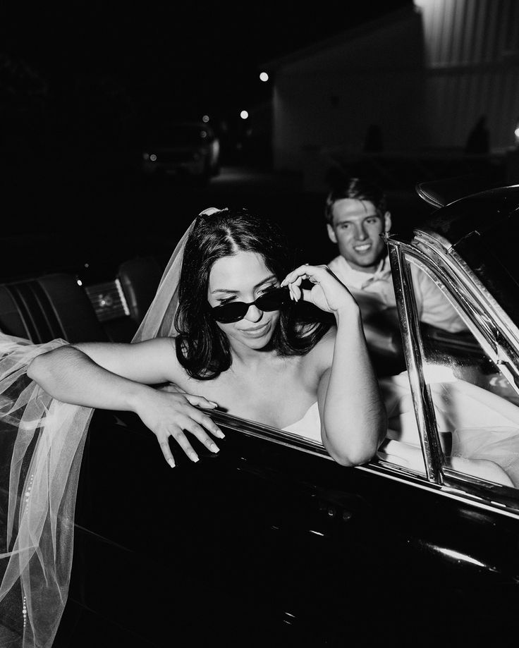 black and white photograph of bride and groom in car