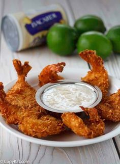 fried shrimp with dipping sauce on a white plate