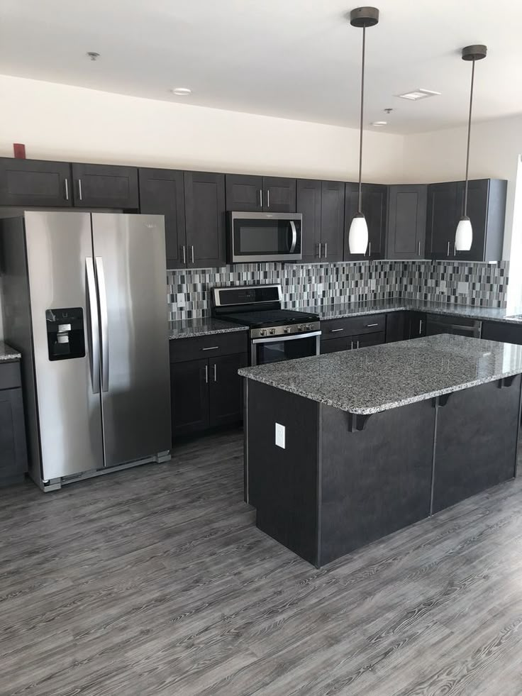 an empty kitchen with granite counter tops and stainless steel appliances