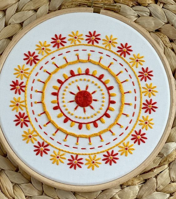 a close up of a embroidery on a piece of wood with flowers and circles in the center