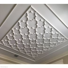 the ceiling in this room is decorated with white paint and decorative designs, including an intricate pattern