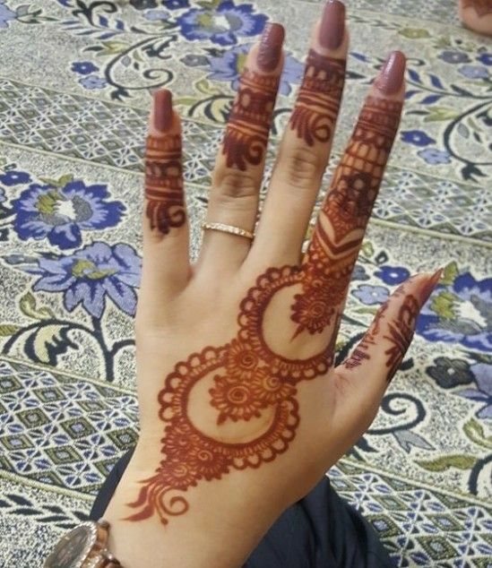 a woman's hand with henna tattoos on it