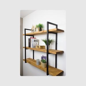 three wooden shelves with plants and books on them