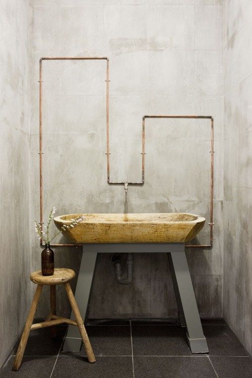 an image of a sink in the middle of a room with metal pipes on it